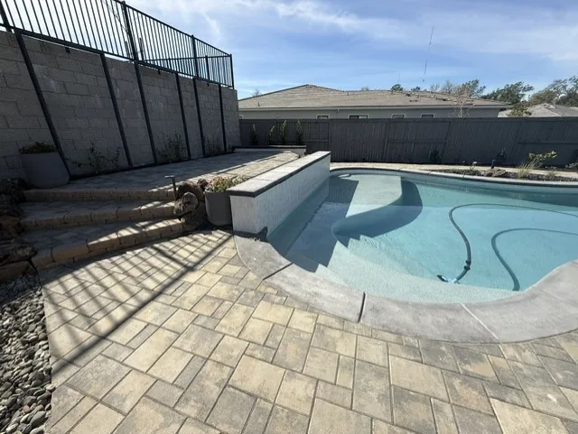 Freeform pool paver deck raised bond beam by Pinnacle Pools and Landscape, Sacramento CA