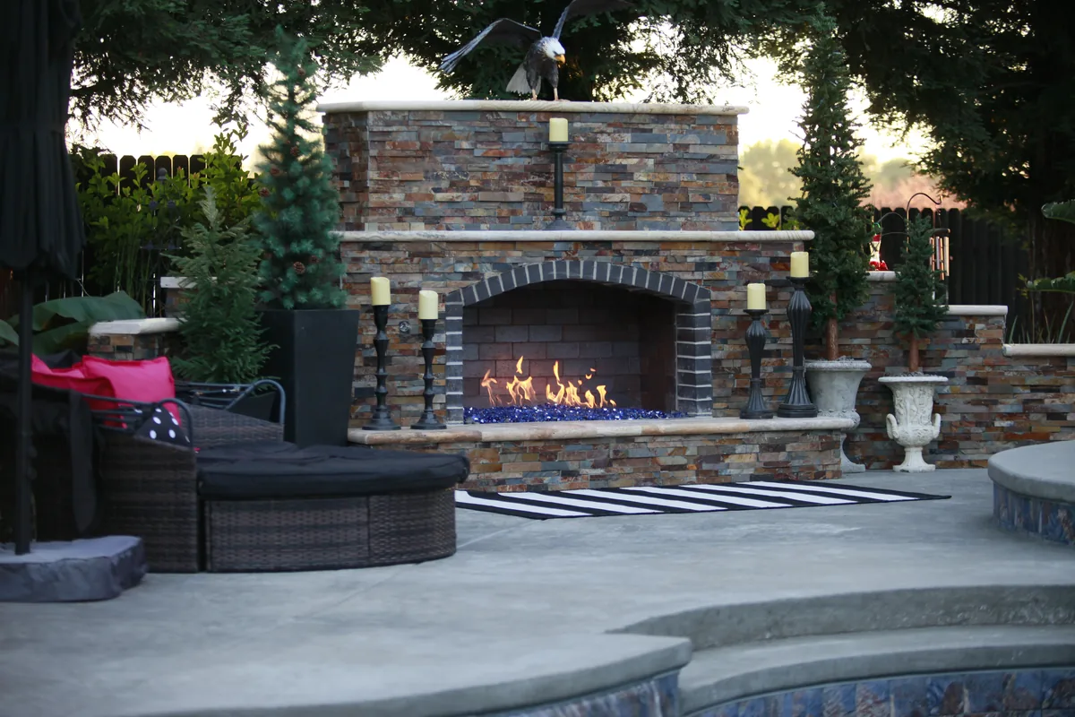 Outdoor fireplace stone patio seating by Pinnacle Pools and Landscape, Sacramento CA