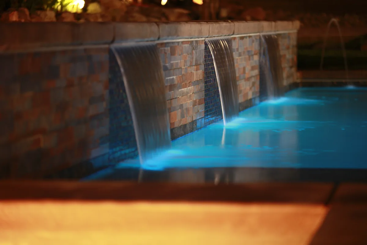 Pool sheer descent waterfall night lighting by Pinnacle Pools and Landscape, Sacramento CA