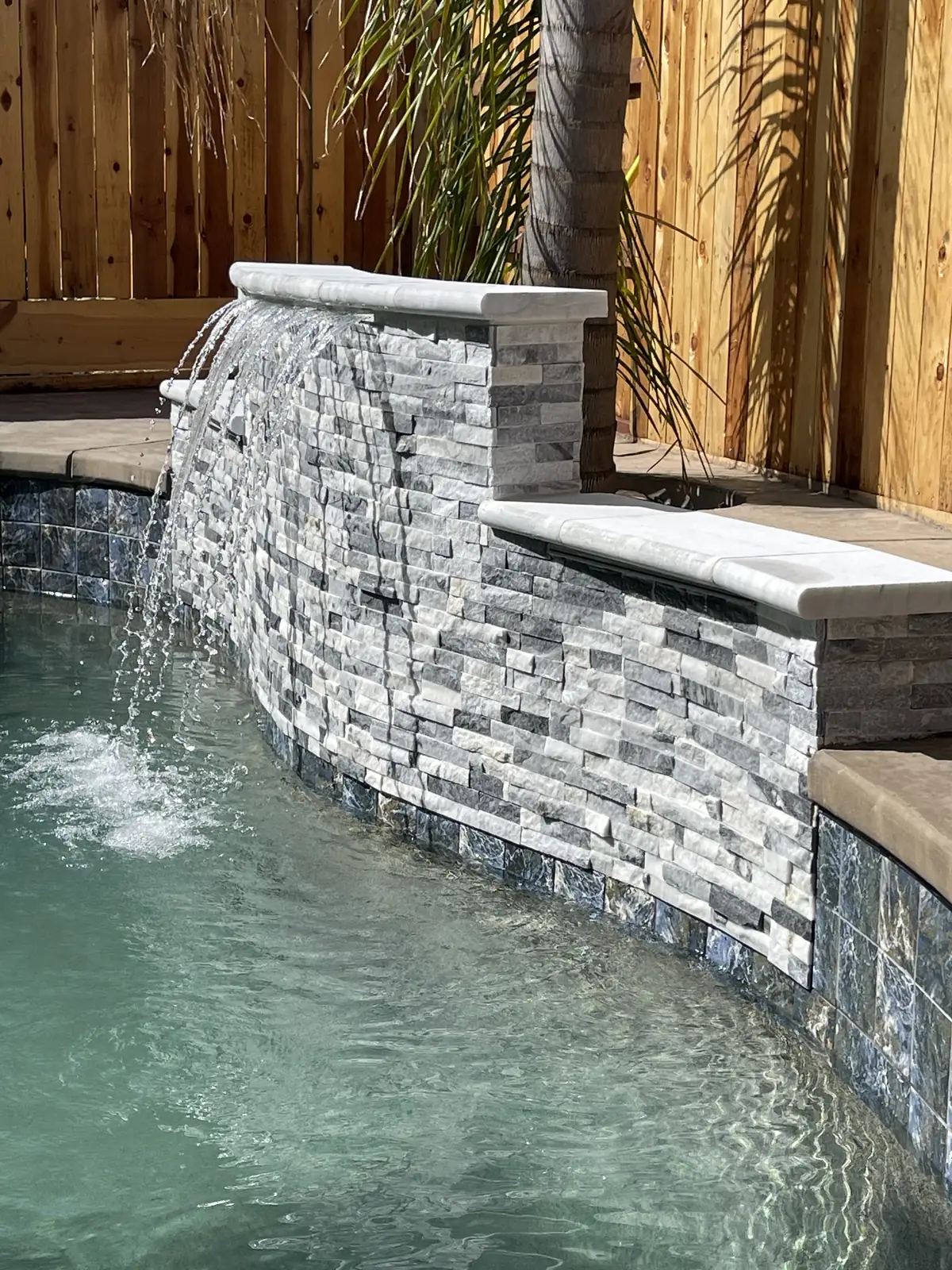 Pool waterfall stacked stone wall by Pinnacle Pools and Landscape, Sacramento CA