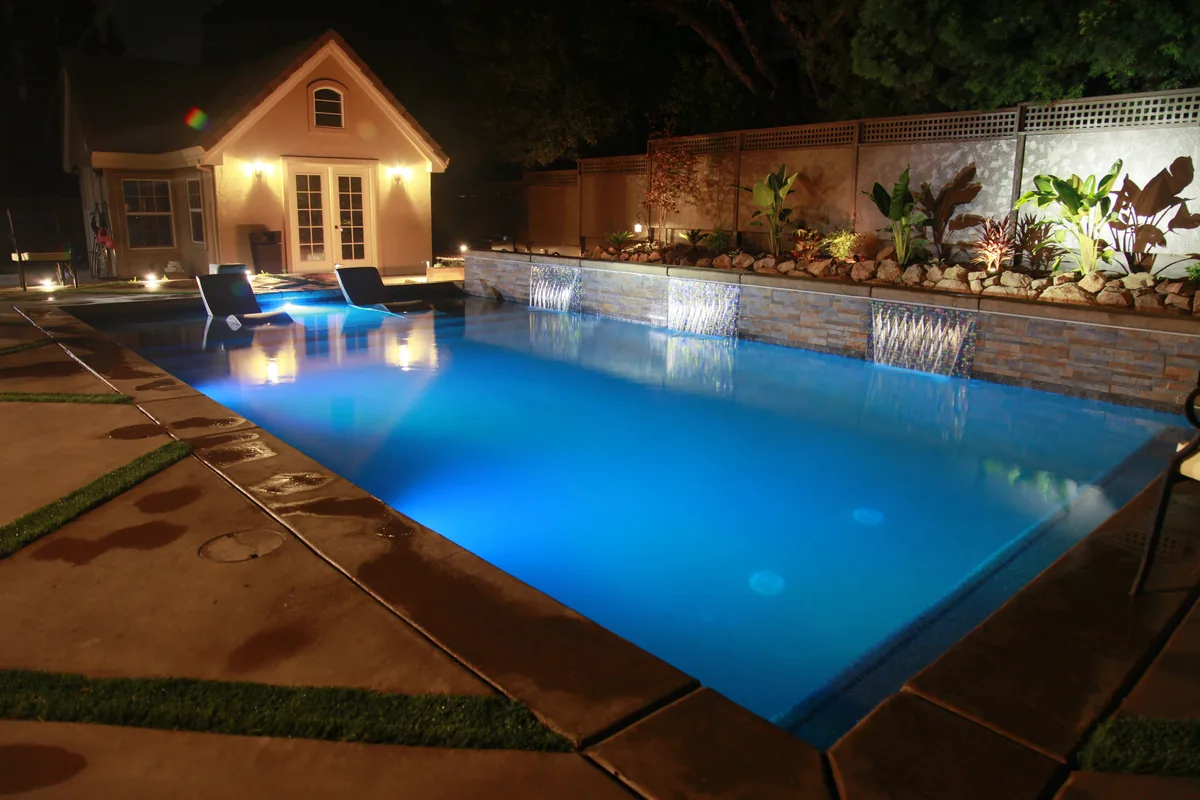 Rectangular pool landscape lighting night by Pinnacle Pools and Landscape, Sacramento CA